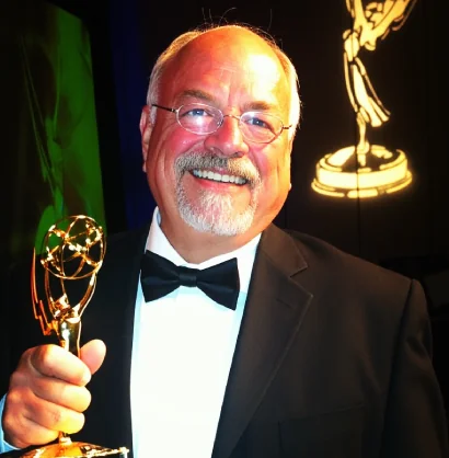 Ron holding an Emmy statuette